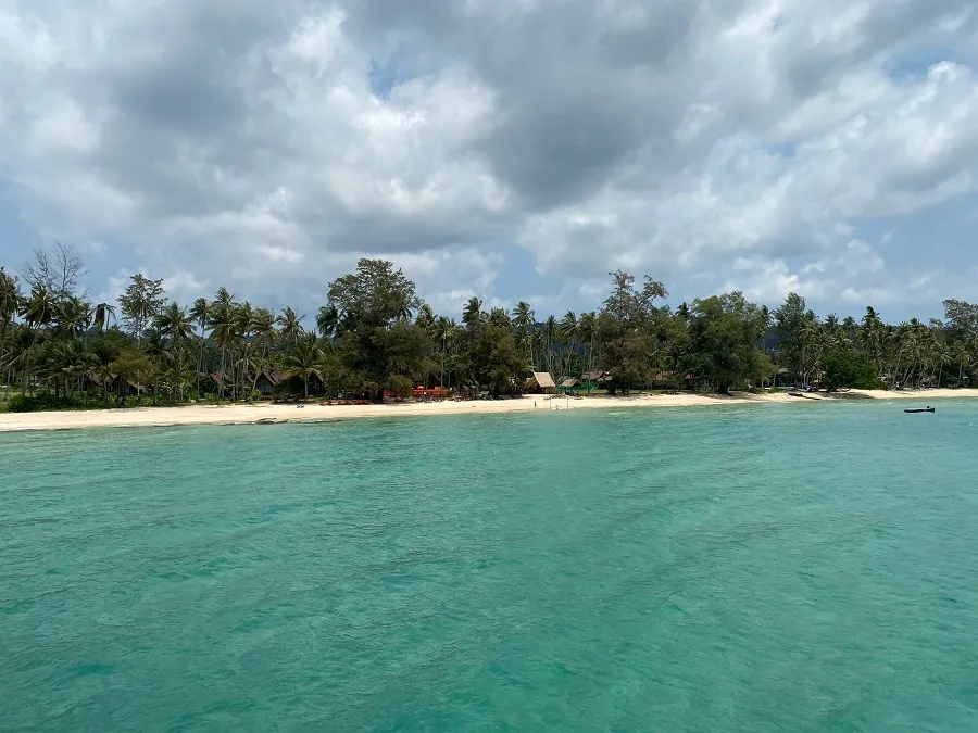 A palm-fringed Koh Kood bay seen across calm turquoise water