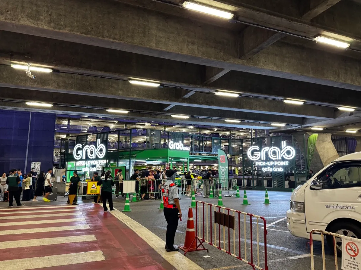 The illuminated green Grab Pick-Up Point at Suvarnabhumi airport, where your driver meets you